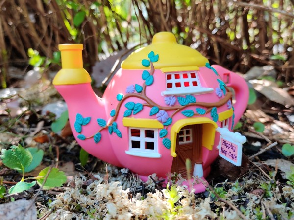A pink Teeny Weeny Families teapot outside in the garden.