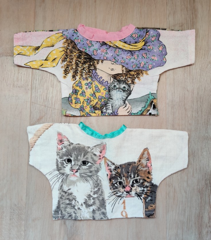 Two homemade doll shirts. The second shirt is made from a 1980's fabric calendar.